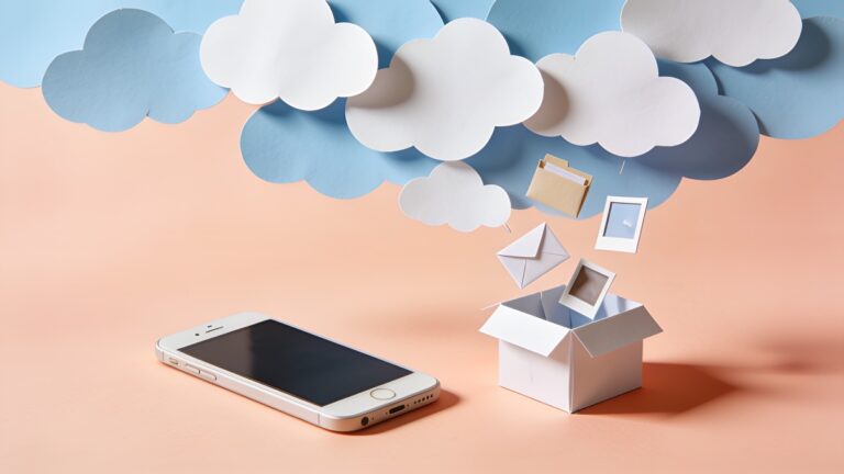 Paper cut-out clouds above a smartphone with envelopes, folders and photos falling out into a box